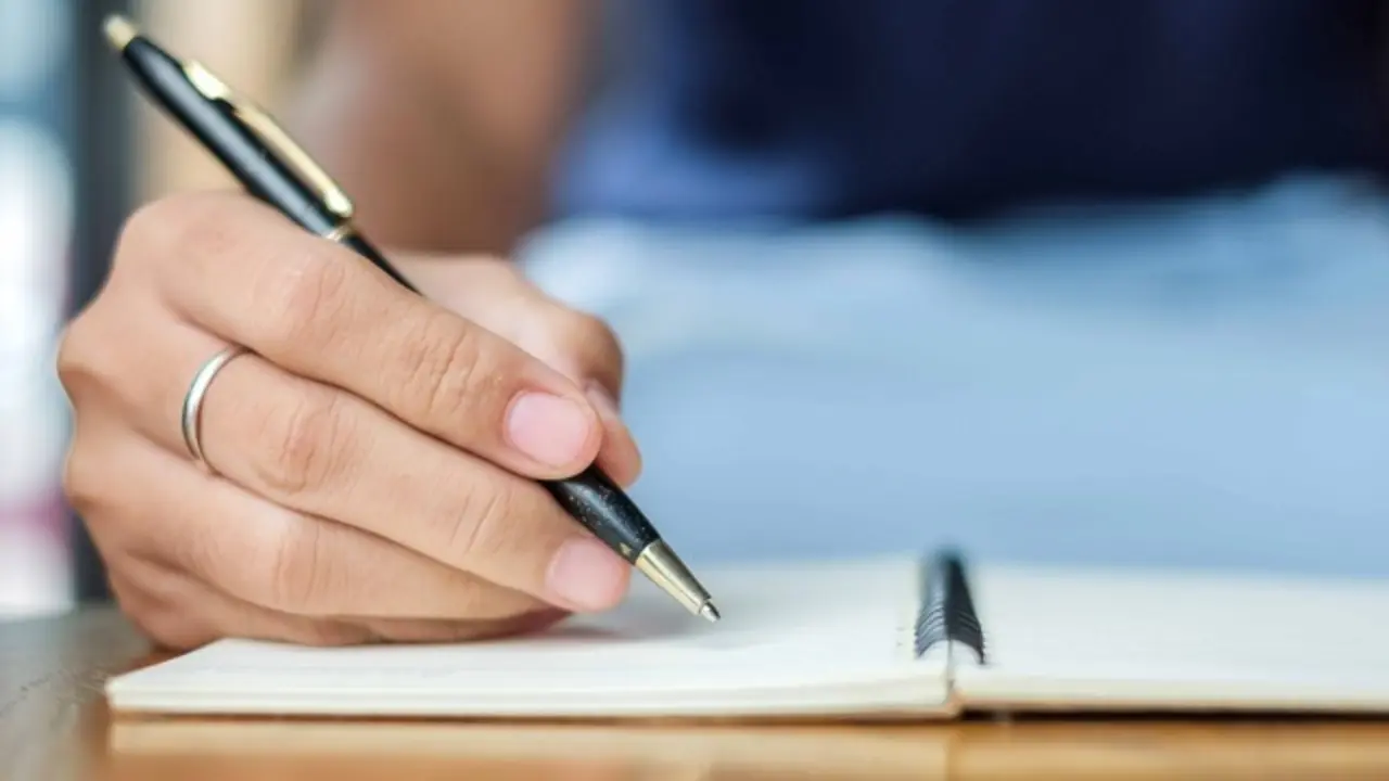 Businesswoman writing something on notebook in office, hand of woman holding pen with signature on paper report. business concepts